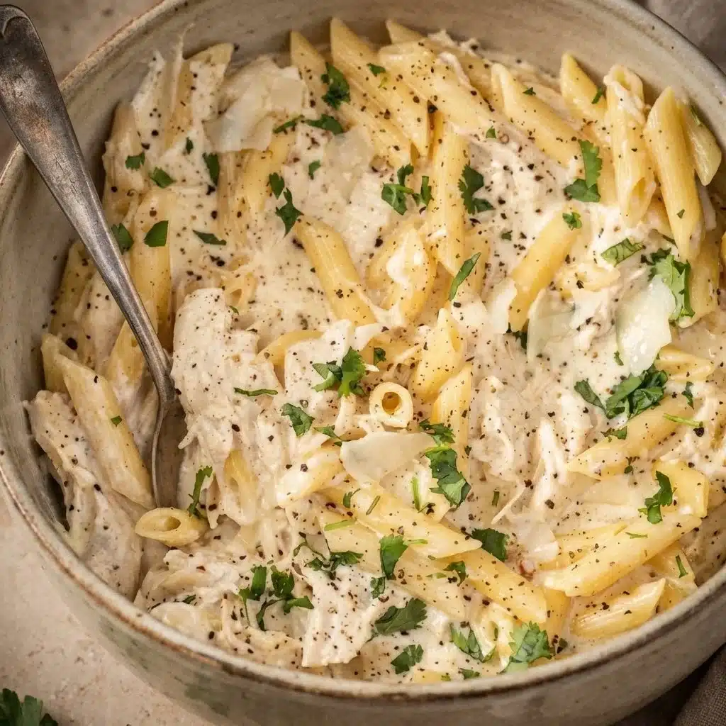 Crockpot Chicken Alfredo served with pasta and garnished with parsley