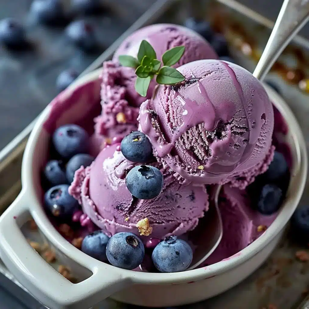 Vegan blueberry cheesecake ice cream in a bowl topped with fresh blueberries